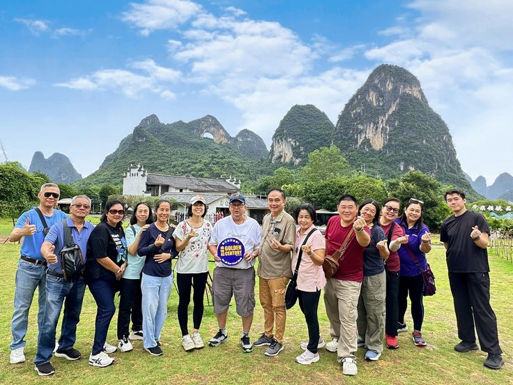 Turistas posando frente a las icónicas montañas kársticas de Yangshuo, cerca de Guilin, en la región de Guangxi, China